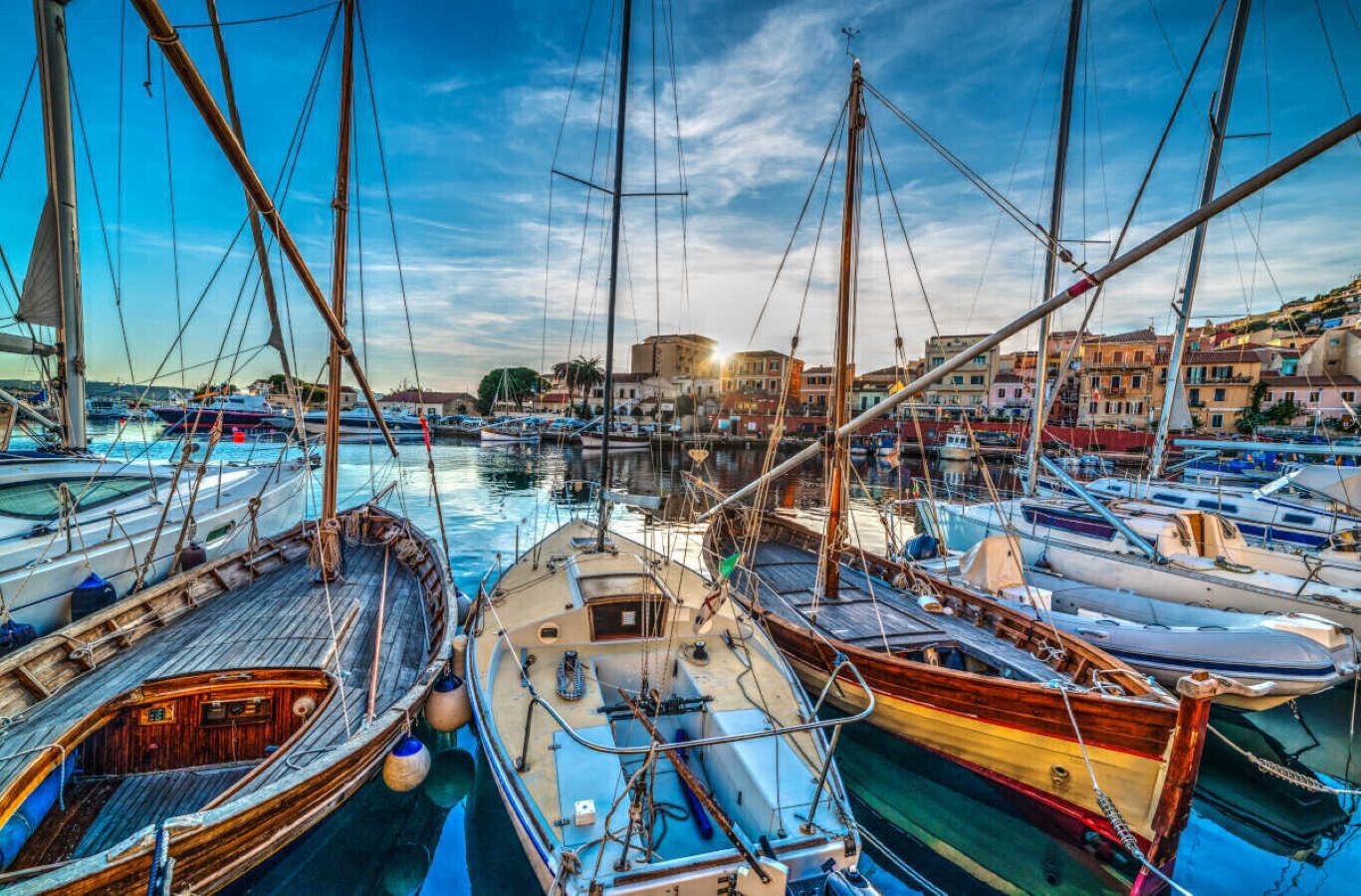 A marina with various boats docked, surrounded by buildings.