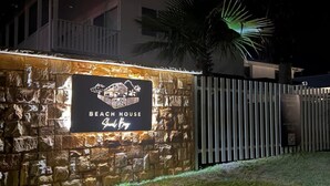 A stone wall with a sign for 'Beach House' in Shreveport.