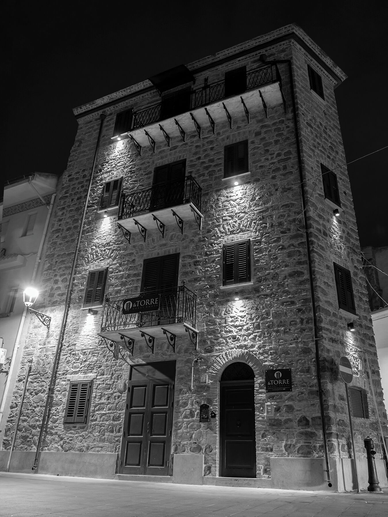 A stone building with multiple balconies and a sign reading "La Torre".