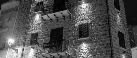 A stone building with multiple balconies and a sign reading "La Torre".