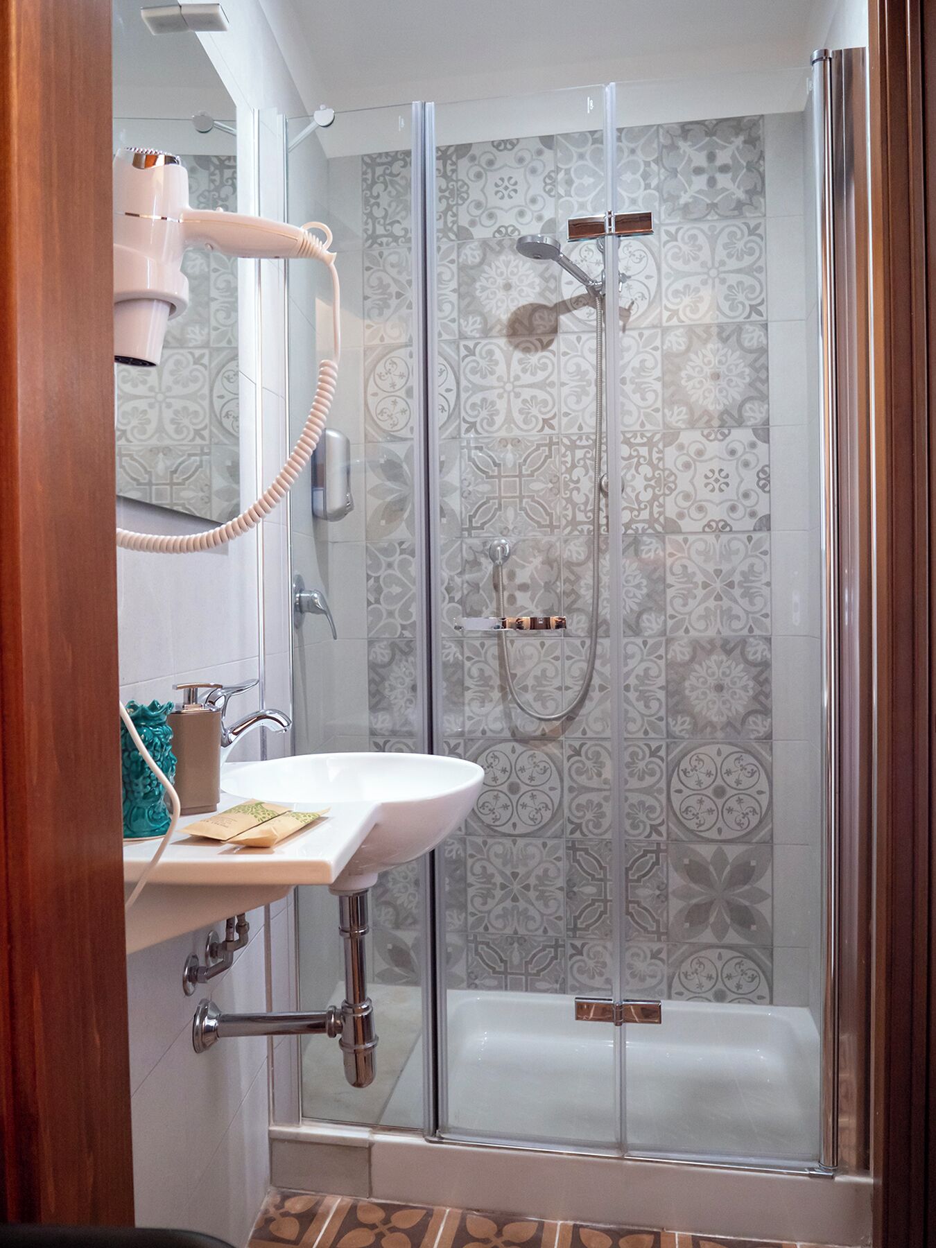 A bathroom with a glass-enclosed shower, a sink with a towel rack, and a bathtub.