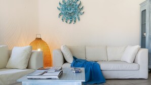 A living room with a white sofa, a coffee table, and a decorative wall piece.