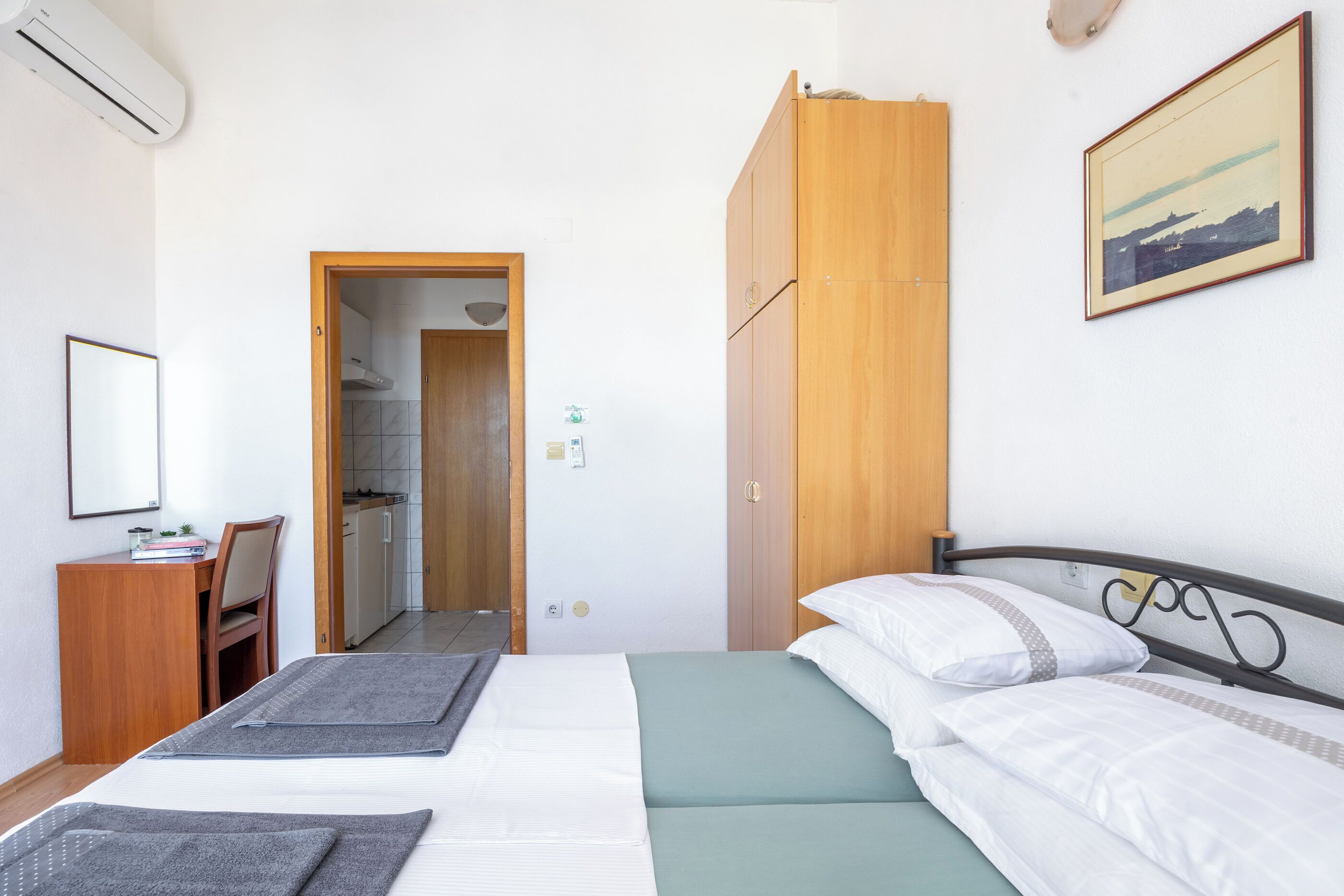 Une chambre à coucher avec un lit, un bureau et une armoire.