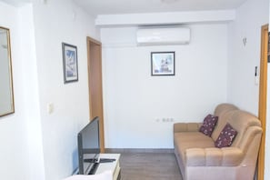 Relax in this cozy space with a sofa, flat-screen TV, and air conditioning for a comfortable stay.