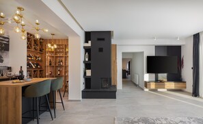 A modern living room with a wooden bar area, a fireplace, and a large flat-screen TV. - Villa La Meravigliosa (Vodice)