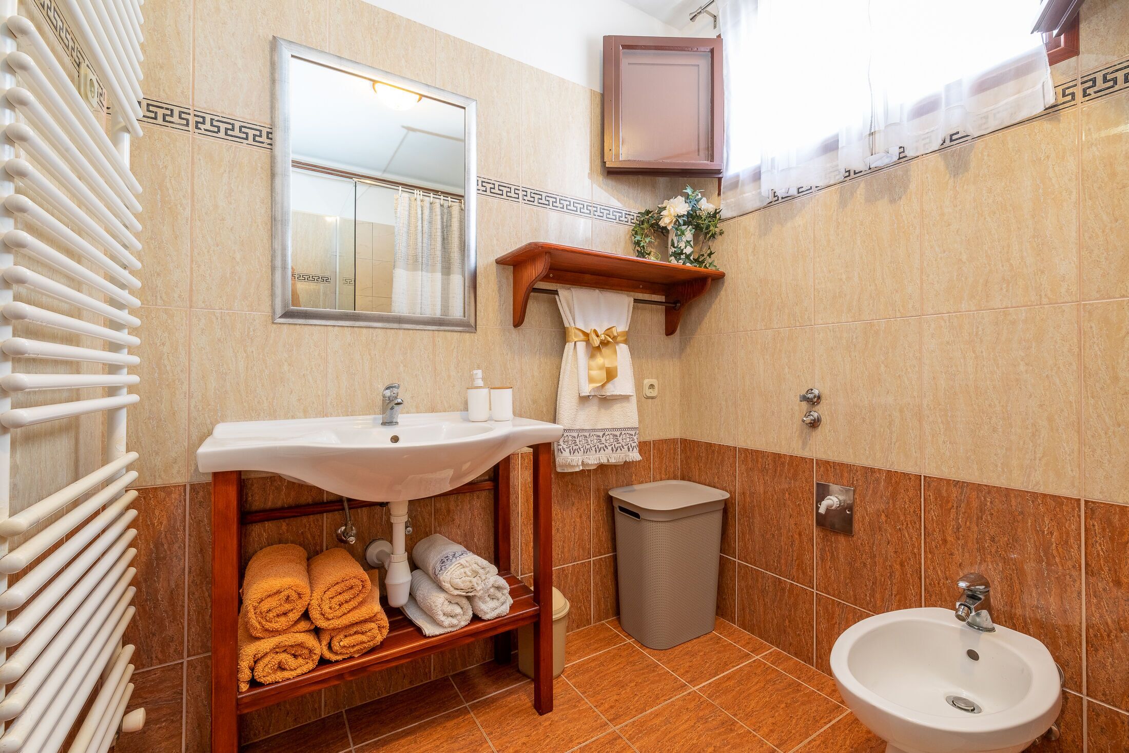 Une salle de bain équipée d’un lavabo, d’un miroir, d’un porte-serviettes et d’une poubelle.