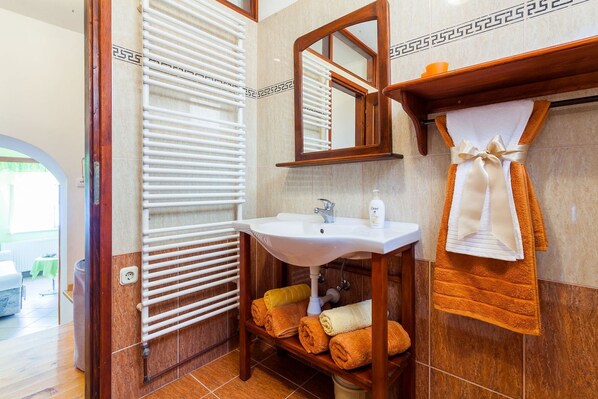 A bathroom with a white sink, wooden vanity, and a towel rack with multiple towels. - Villa Linda (Prigradica)