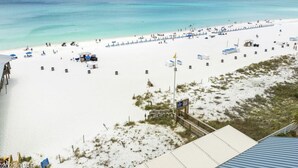 Ein Strand mit einer langen Mole, weißem Sand und klarem türkisblauem Wasser.