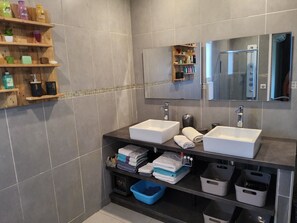 Chuveiro, secador de cabelo, toalhas de banho, papel higiênico