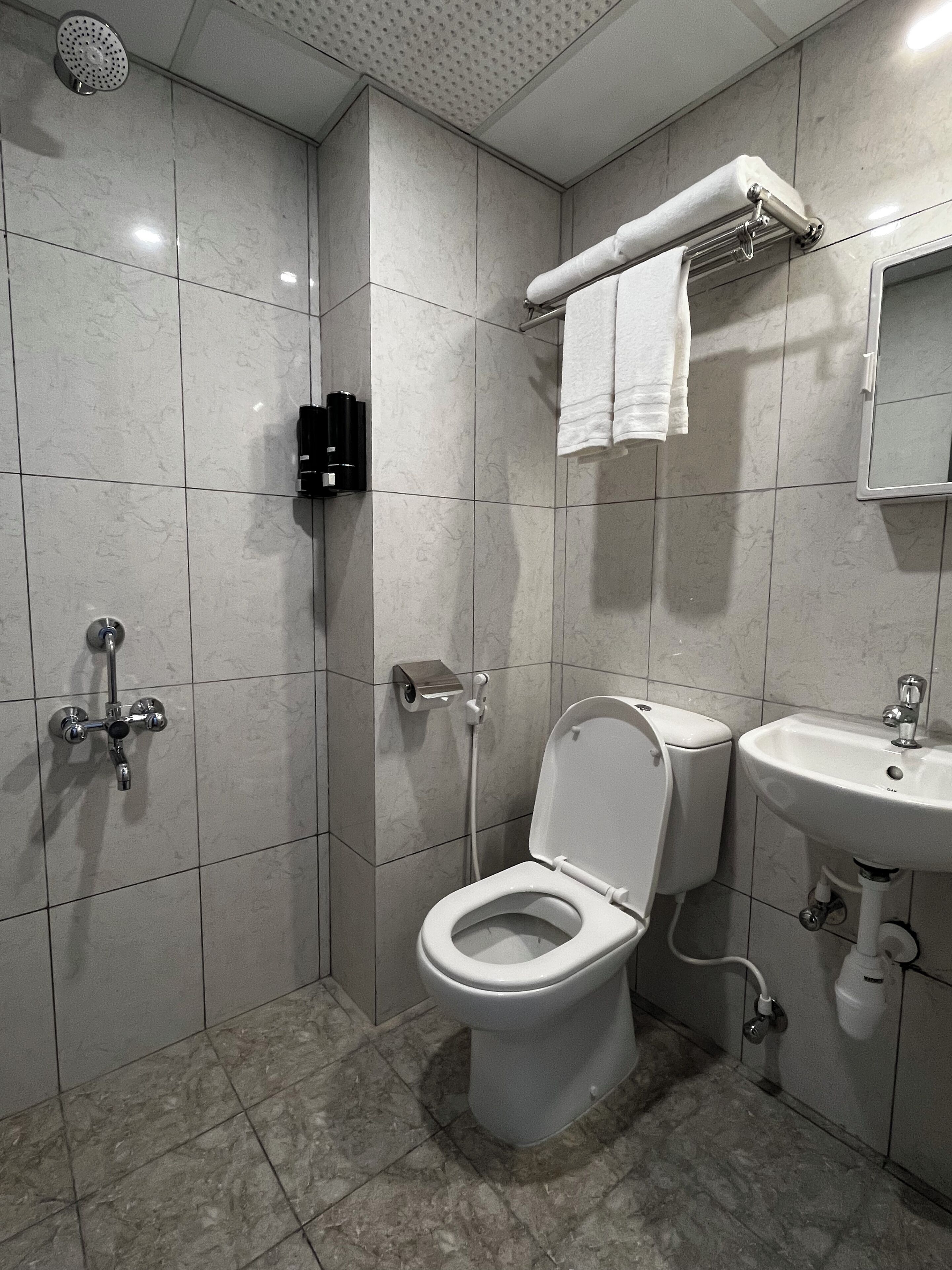 A modern bathroom with a toilet, sink, and shower.
