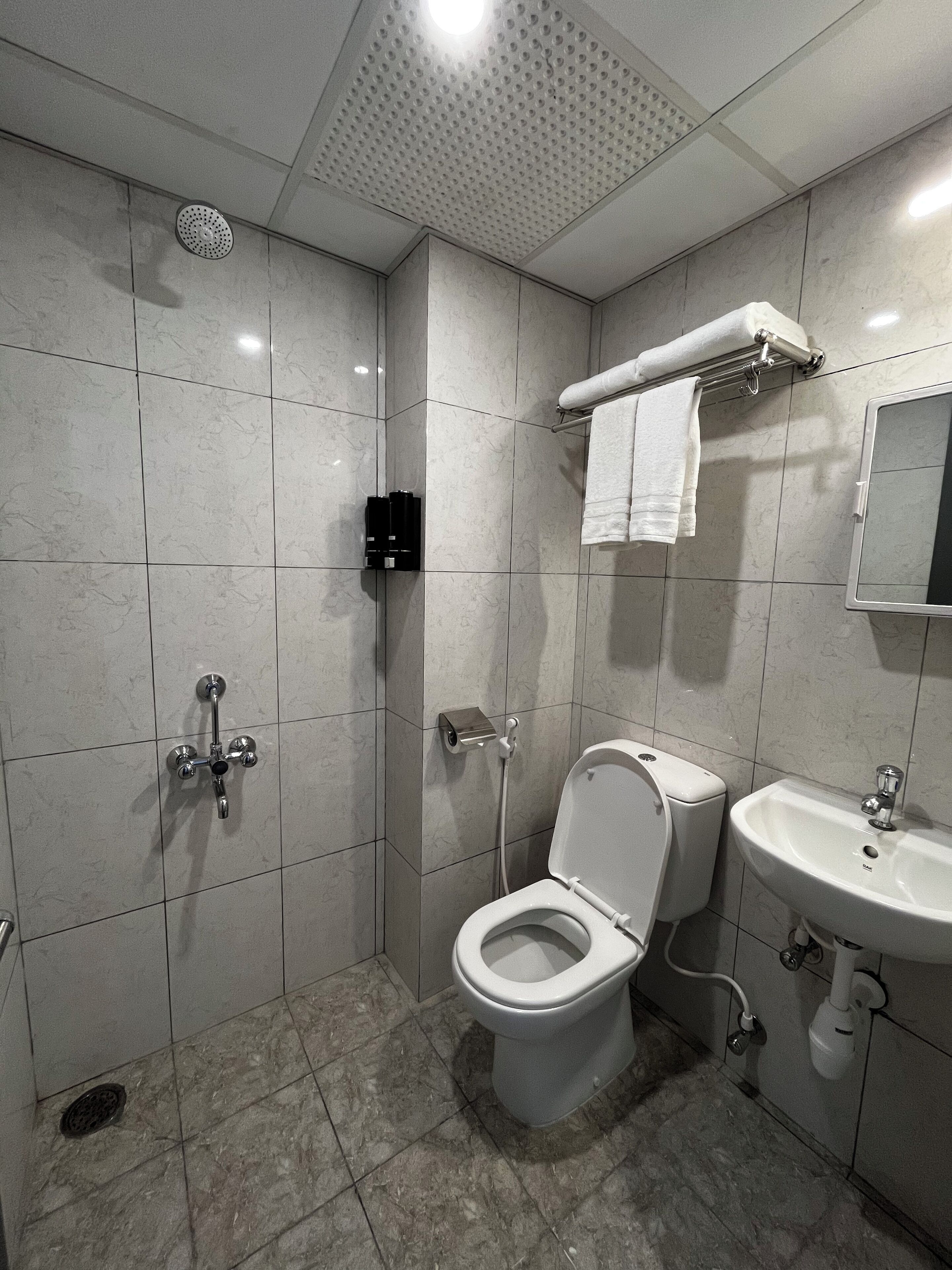 Ein modernes Badezimmer mit Toilette, Waschbecken und Dusche.