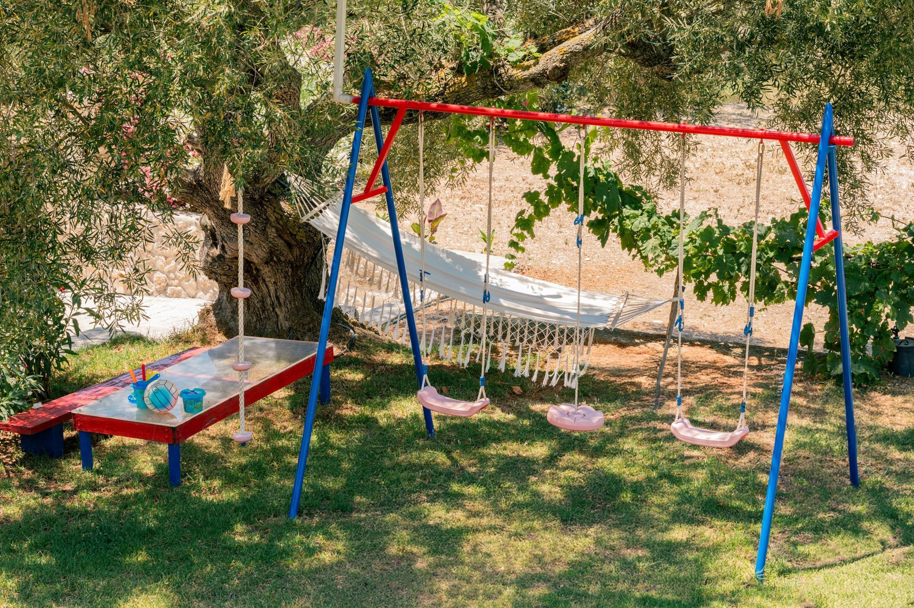 A playground with swings and a table with toys.