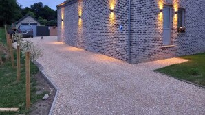 Edificio de ladrillo con camino de grava y señal de estacionamiento.