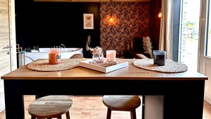 Una mesa de madera para comer con individuales, velas y un centro de mesa.