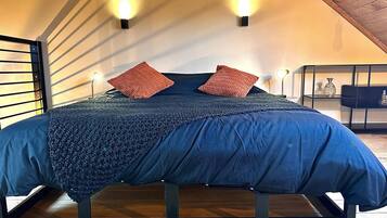 Una camera da letto con un letto, due luci a parete e un soffitto in legno.