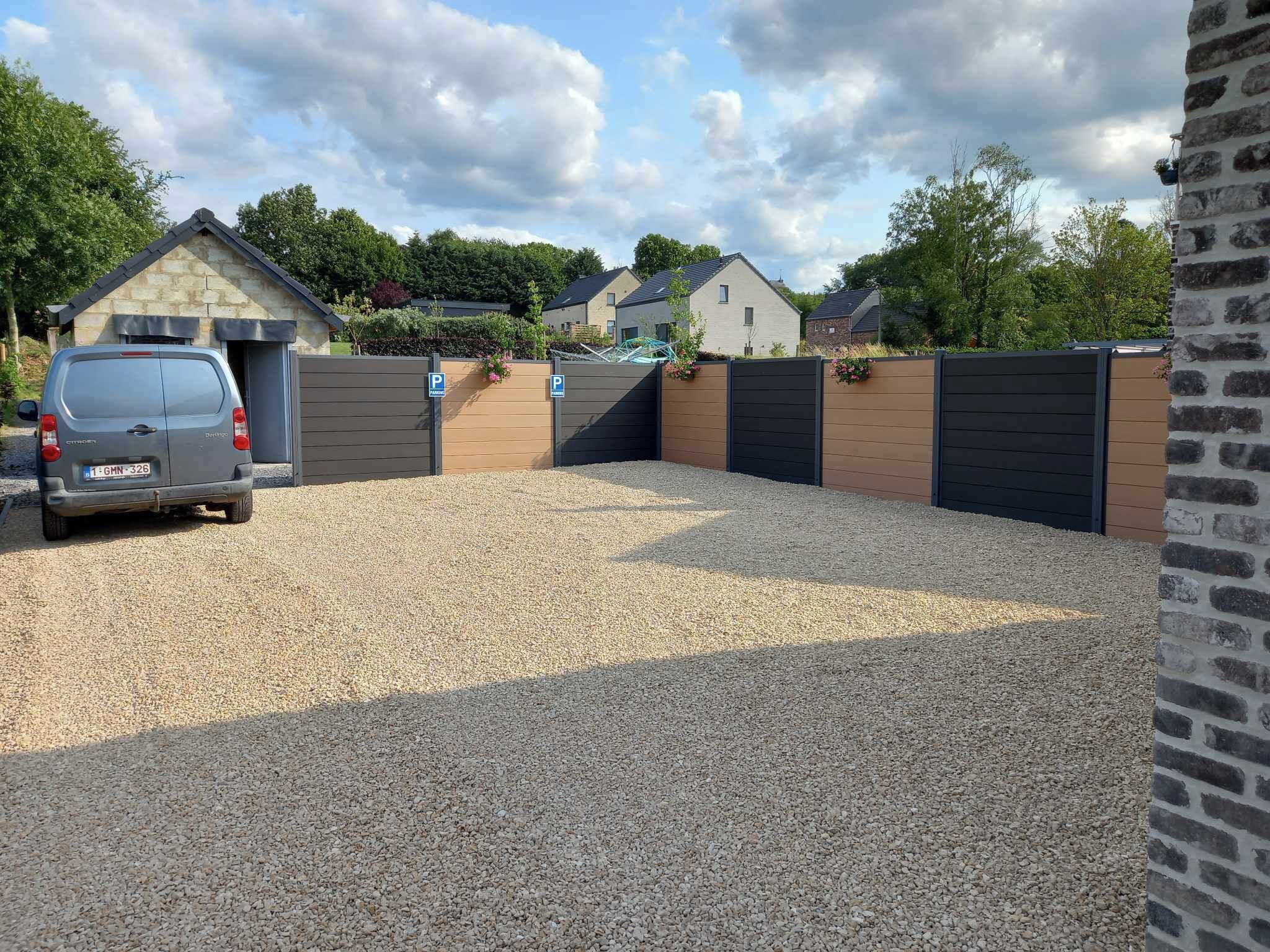 Ein Schotterweg führt zu einem verschlossenen Eingangsbereich, wo ein Auto geparkt ist.