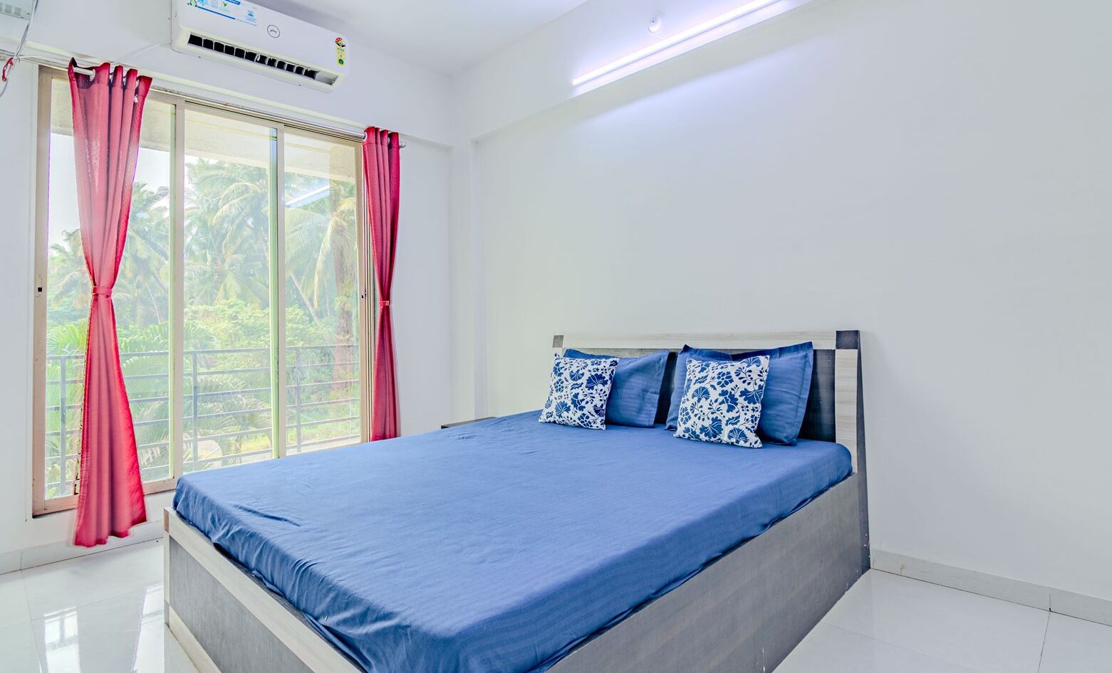 Un dormitorio con cama, ventana con cortinas y unidad de aire acondicionado.