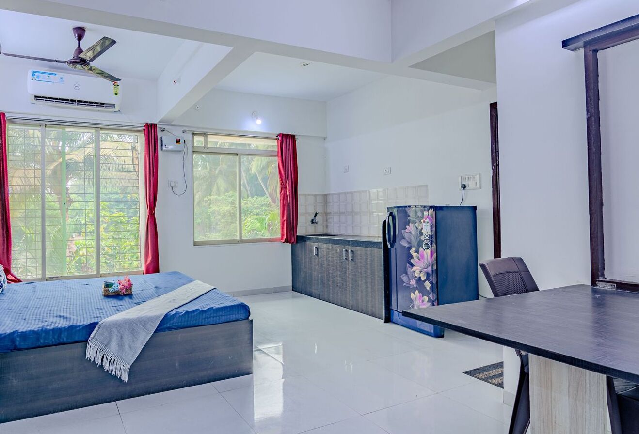 Una habitación moderna con cama, escritorio y kitchenette.