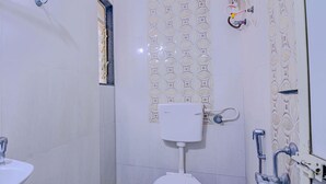 Une petite salle de bain avec des toilettes, un lavabo et une douche.