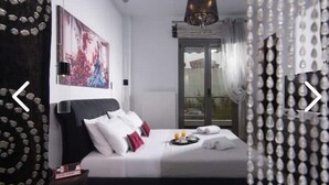Ein modernes Schlafzimmer mit Bett, Nachttisch, einem Fenster mit Vorhängen und einem Bild an der Wand.