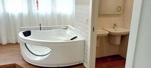 A modern bathroom with a freestanding bathtub, a sink, and a toilet. - Apartamentos el Beyu (Cangas de Onis)