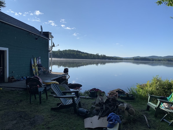 Un chalet au bord du lac, doté d’un quai, d’un espace salon extérieur et d’équipement de pêche.