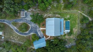 An aerial view of a property with a large building, a swimming pool, and a winding driveway. - The Point-Hill Country Views-Pool+Hot Tub (Fredericksburg)