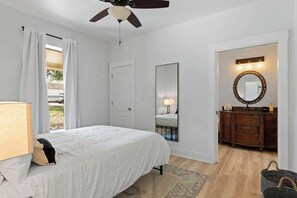 A bedroom with a bed, a ceiling fan, a dresser, and a mirror. - The Point-Hill Country Views-Pool+Hot Tub (Fredericksburg)