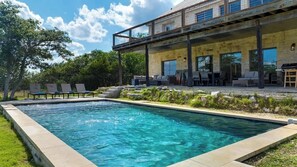 A modern outdoor pool area with lounge chairs and a covered patio. - The Point-Hill Country Views-Pool+Hot Tub (Fredericksburg)