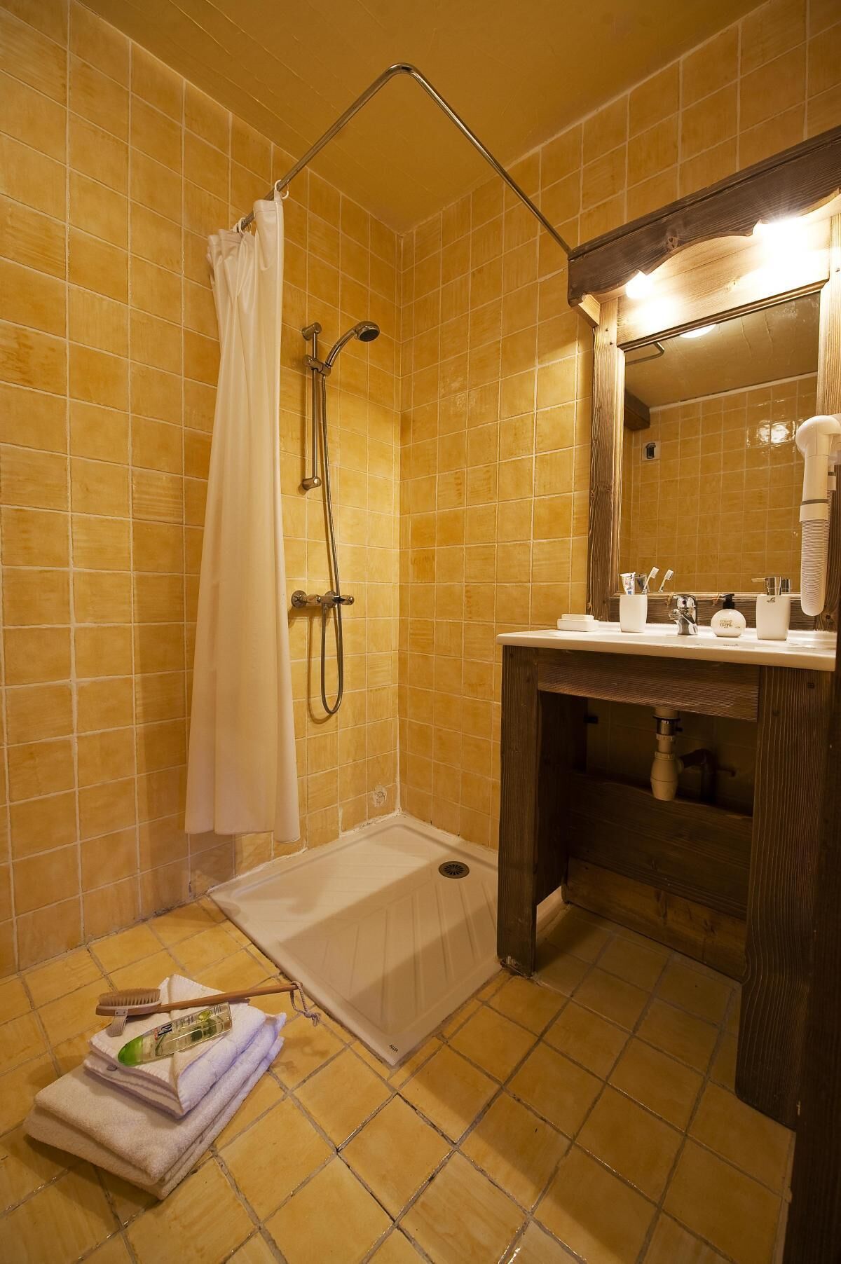 Ein Badezimmer mit Dusche, Waschbecken und gefliesten Wänden.