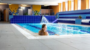 A swimming pool with a water feature, tiled walls, and a tiled floor. - ibis Styles Relax Roznov pod Radhostem (Roznov Pod Radhostem)