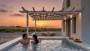 A couple in a hot tub with a sunset view, a pergola, and a table with food and drinks. - Private Jacuzzi Villa w/sunset view 6' from sea (OÃ­a)