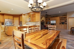 A spacious kitchen with wooden cabinets, a large island, and a dining area with a wooden table and chairs.