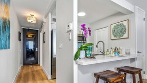 A hallway with a wooden floor, a door, and a ceiling light fixture.