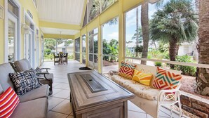 A covered patio area with a sofa, chairs, and a table.