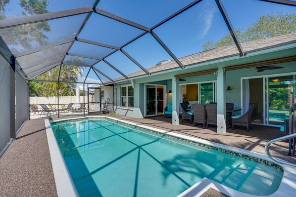 Una piscina cubierta con techo de vidrio, mobiliario exterior y vistas del entorno.