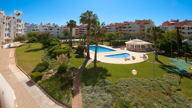 A residential complex with a swimming pool, palm trees, and a well-maintained garden. - Ondas Verdes - Central, Pool & Tenis Court (Albufeira)