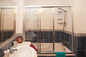 Banheira, secador de cabelo, toalhas de banho, shampoo