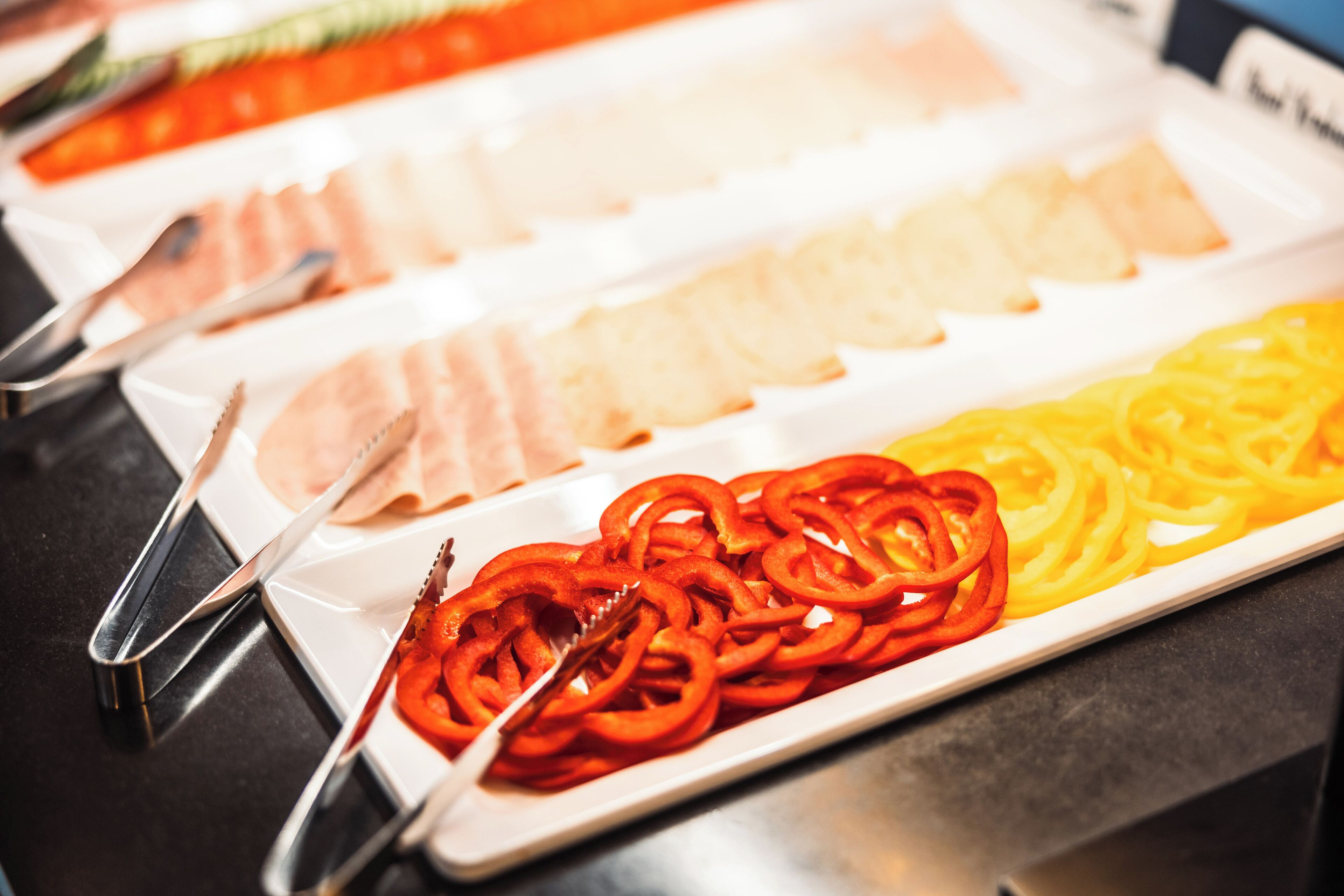 Un buffet proposant une variété de plats, notamment des viandes et des légumes coupés en tranches.