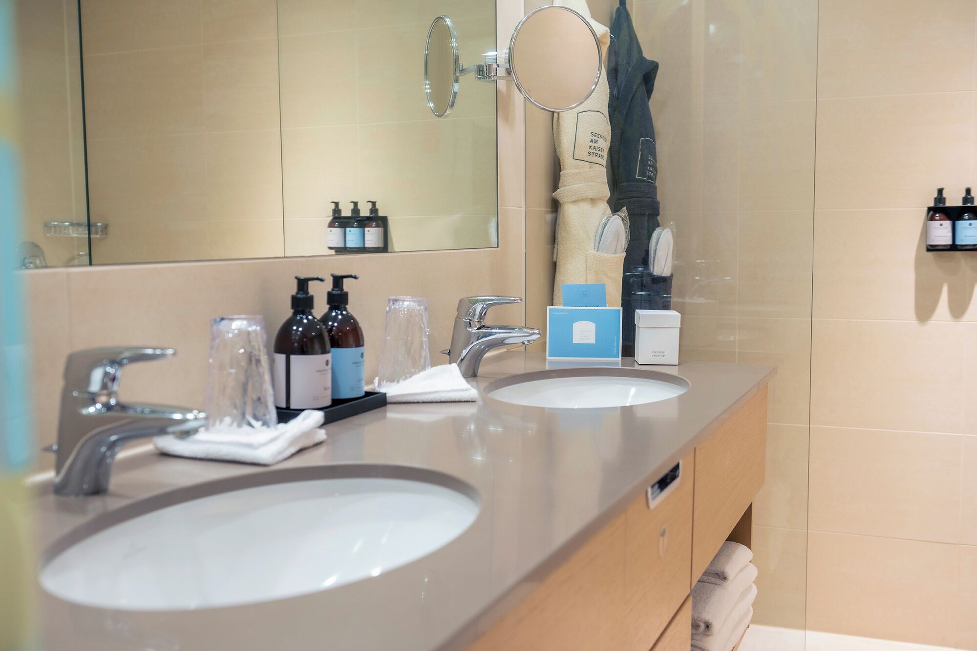 A bathroom with two sinks, a mirror, and toiletries.