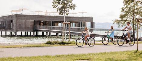 A riverside walkway with a wooden structure and umbrellas.