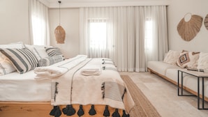 Et moderne soveværelse med en stor seng, en sofa og et skrivebord.