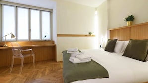 A hotel room with a bed, a desk, a chair, and a window. - Sweett | Maison Laghetto (Milano)