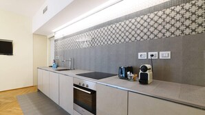 A modern kitchen with a built-in oven, a sink, and a countertop with a toaster and a coffee maker. - Sweett | Maison Laghetto (Milano)