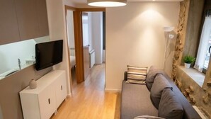 Ein modernes Wohnzimmer mit einer Couch, einem Flachbildfernseher und einem Schrank.