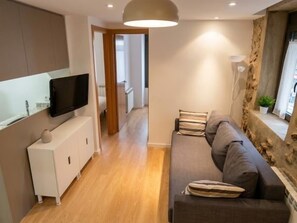 Un salon moderne avec un canapé, un téléviseur à écran plat et un meuble.