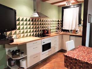 Een oven, een broodrooster, kookgerei, borden en bestek