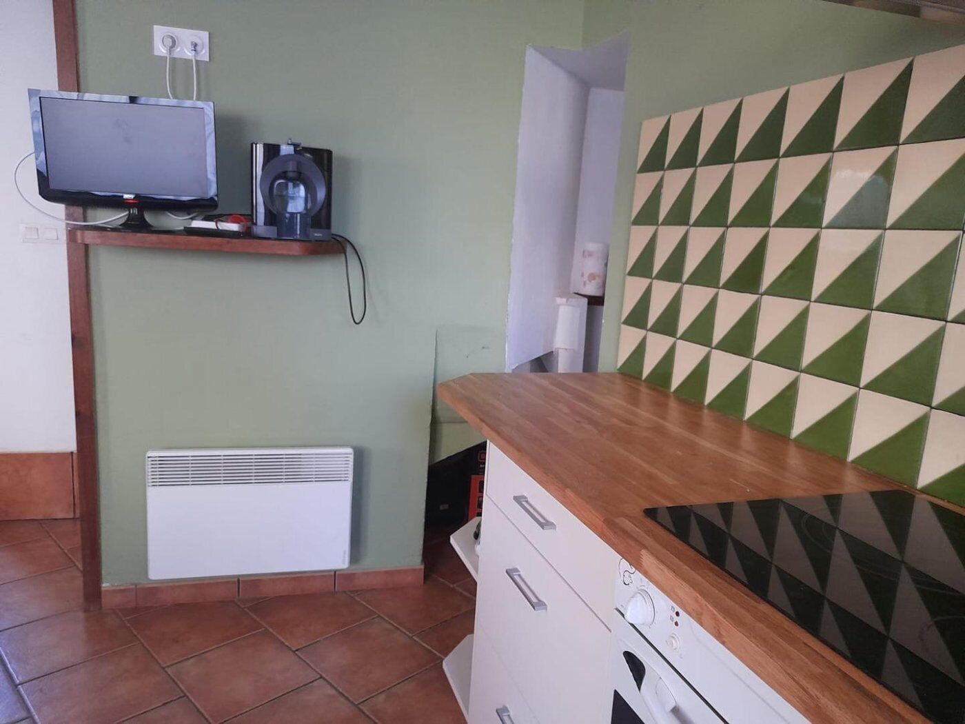 Une cuisine avec un dosseret carrelé, un four encastré et un plan de travail.