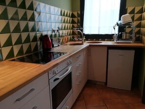 Een oven, een broodrooster, kookgerei, borden en bestek