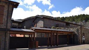 A stone building with a covered entrance and a garage. - Ground Floor 3 rooms Pool, Fireplace, Garden & Wi-Fi (Queixans)